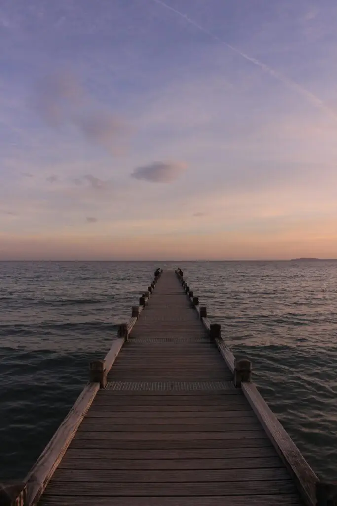 Serene sunset view from a wooden dock over calm waters, perfect for relaxation.