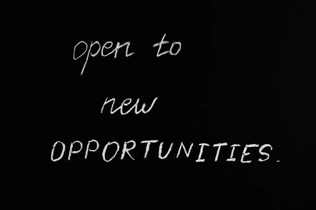 Blackboard with motivational quote 'Open to New Opportunities' in chalk writing.